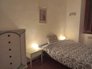 利沃诺L'Iris的一间卧室配有一张床和一个带两盏灯的梳妆台。