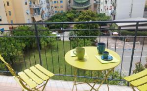 索伦托CASA Eduardo e Titina的阳台上的黄色桌子,上面有两杯椅子