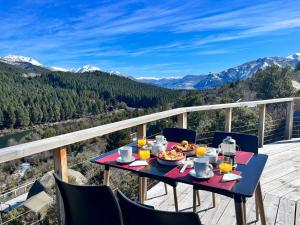 维拉梅利奎纳Terrazas de Meliquina的山景阳台上的餐桌,配有食物和饮料