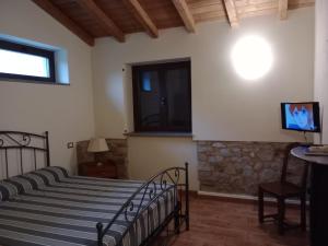 TresanaCa Giacomo的一间卧室配有一张床,墙上配有电视