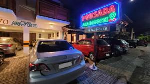 普拉亚多Pousada Ana do Forte的酒店门前设有停车场,可停放汽车