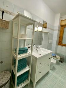 LʼAmericanoMarina Residence的浴室设有水槽和带毛巾的白色架子。