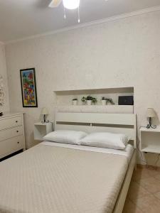 LʼAmericanoMarina Residence的一间卧室配有一张带2个床头柜的大型白色床