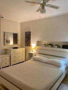 LʼAmericanoMarina Residence的一间卧室配有一张床和吊扇
