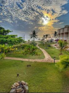Ḩumrفندق حدائق فرسان الفندقية的棕榈树公园和日落背景