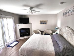 北怀尔德伍德2310 Central Avenue的一间卧室配有一张床、一个壁炉和一台电视。