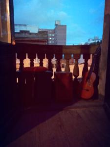 蒙得维的亚Casa Copada的坐在阳台的顶端的吉他