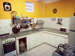 蒙得维的亚Casa Copada的厨房设有黄色的墙壁、白色的橱柜和水槽