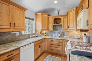 大熊湖Cozy Cabin perfect for 2 Families的厨房配有木制橱柜和白色家电