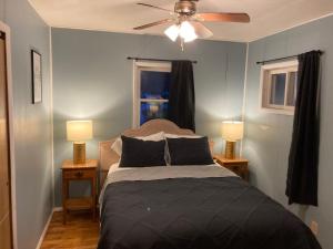 霍利Wally's Cabin的一间卧室配有一张带两盏灯的床和吊扇。