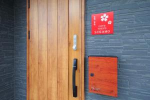 东京COTO Tokyo Sugamo的墙上有标志的木门