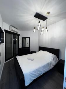 提比里亚Lake Breeze of Tiberias的卧室配有一张带灯的白色大床