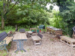 YaldingShepherds Hut 1 At Laddingford - Uk32531的一组野餐桌和长凳在院子里