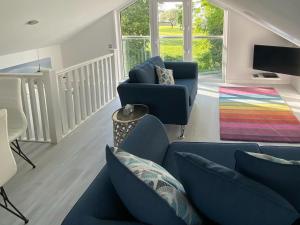 Saint LawrenceRainbows End的客厅配有蓝色的沙发和色彩缤纷的地毯。