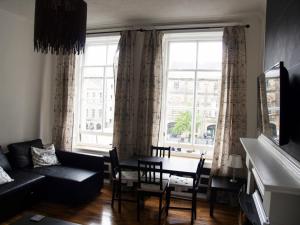 爱丁堡爱丁堡尼德里街公寓的客厅配有沙发和窗户前的桌子