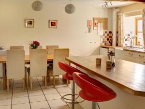 斯通豪斯Leonard Barn的厨房配有木桌和红色椅子
