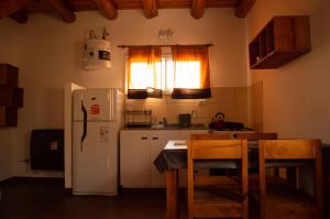 卡皮亚德尔德尔蒙特Cabaña La Yumba的厨房配有冰箱和桌椅