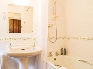 WollastonThe Hill Cottage Apartment的白色的浴室设有水槽和浴缸。