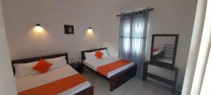 阿努拉德普勒Lake Edge Resort的一间小卧室,配有两张床和镜子