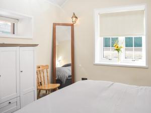 Kirktown of AuchterlessThe Bothy的卧室配有白色的床和镜子
