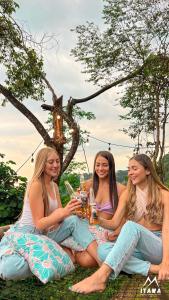 比亚维森西奥Glamping Itawa & Ecoparque turístico的三个女人坐在桌子旁,喝杯酒