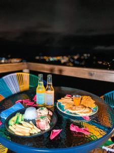 比亚维森西奥Glamping Itawa & Ecoparque turístico的一张桌子,上面放着两盘食物和两瓶啤酒