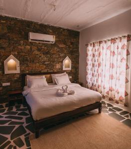 布什格尔The Luxe Pushkar By Namli Hotels的一间卧室设有一张床和砖墙