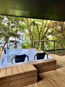 比亚维森西奥Itawa Luxury Glamping & Ecoparque turísticos的甲板上的浴缸,配有两把椅子