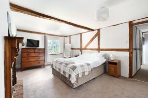 拉斯廷顿Walnut Tree House的一间卧室配有一张床、一个梳妆台和电视。