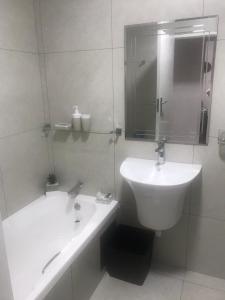约翰内斯堡Alendo Apartments的白色的浴室设有水槽和浴缸。