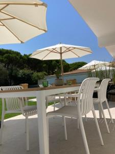 阿利卡纳斯Ayïa suites的一张带两把椅子的白色桌子和一把伞