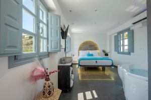 安坡里奥圣托里尼BlackStone Luxury Suites的卧室配有1张床、浴缸和水槽。