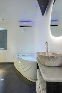 安坡里奥圣托里尼BlackStone Luxury Suites的浴室配有盥洗盆和浴缸。