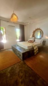 江比阿Garden Beach Bungalows Jambiani的一间卧室配有一张大床和镜子