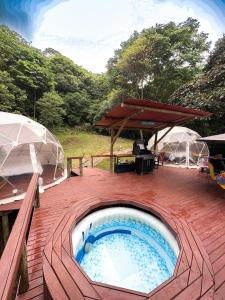 比亚维森西奥Glamping Itawa & Ecoparque turístico的甲板上的热水浴池配有2把遮阳伞