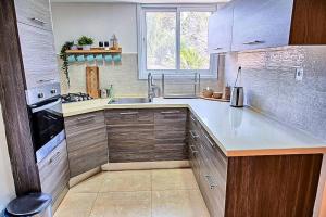 米茨佩·拉蒙זמן מדבר的厨房配有木制橱柜、水槽和窗户。