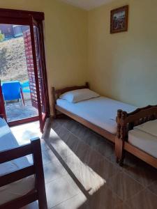 蒂瓦特Apartmani Miholjska prevlaka的一间卧室设有两张床和滑动玻璃门