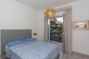 阿马尔菲Villa Lelle Amalfi的一间卧室配有一张带蓝色枕头的床和一个阳台
