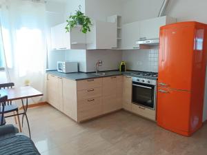 圭尔福堡San Carlo House的厨房配有橙色冰箱和白色橱柜