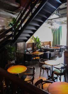 成都Sonderia Hostel & Bar - Lazybones Hostel的一间带桌椅的餐厅,以及楼梯