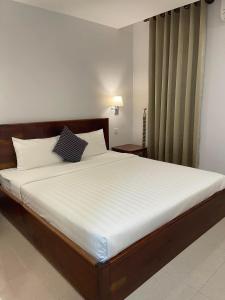 Chhay Ing Guesthouse的一间卧室配有一张带白色床单的大床