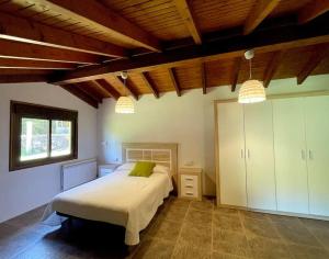 CoveloEspectacular casa en Covelo的一间带一张床的卧室,位于带木制天花板的房间内