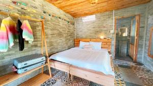 潘切Me Bungalow Beach Resort的木制客房内的一间卧室,配有一张床