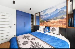 新塔尔格Corna Owca的卧室配有一张蓝色的床,墙上挂着一幅画