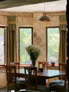 安布罗劳里Hotel Nordmann,Racha的一间带桌子和2个窗户的用餐室