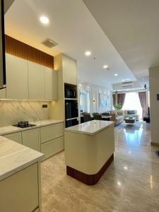 棉兰Insta-worthy staycation at 2BR luxury Apt - Podomoro Empire Tower的一间大厨房、白色橱柜和一间客厅