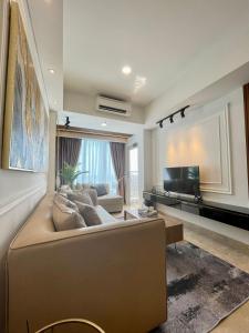 棉兰Insta-worthy staycation at 2BR luxury Apt - Podomoro Empire Tower的带沙发和电视的大型客厅