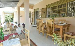 恩德培Cycad Entebbe Guest House的厨房以及带桌椅的用餐室。