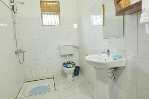 恩德培Cycad Entebbe Guest House的白色的浴室设有卫生间和水槽。