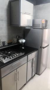 ‘Ezbet Abd el-Hâdi ‘AfîfiIsmailia的厨房配有炉灶和冰箱。